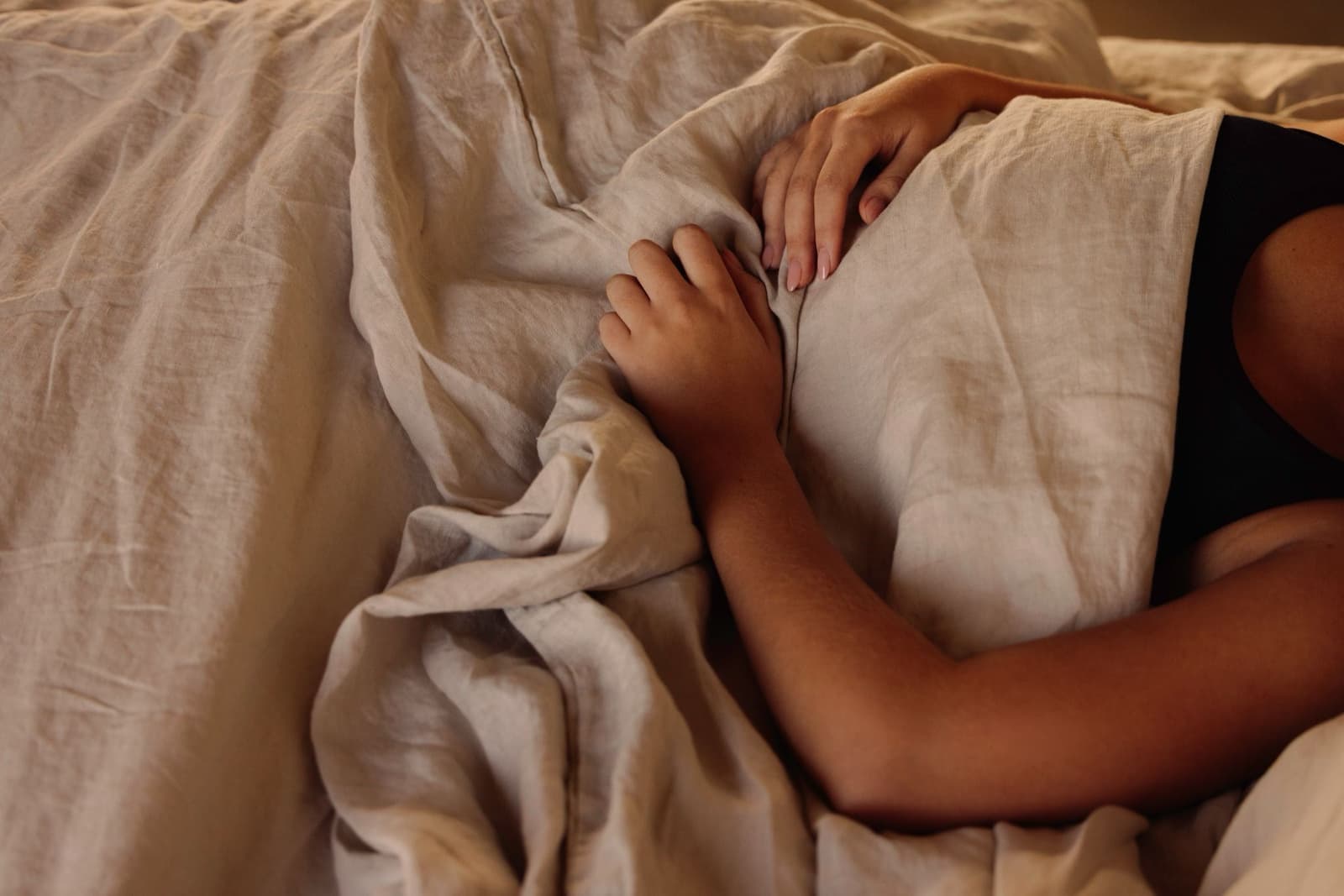 Someone resting in bed under a duvet