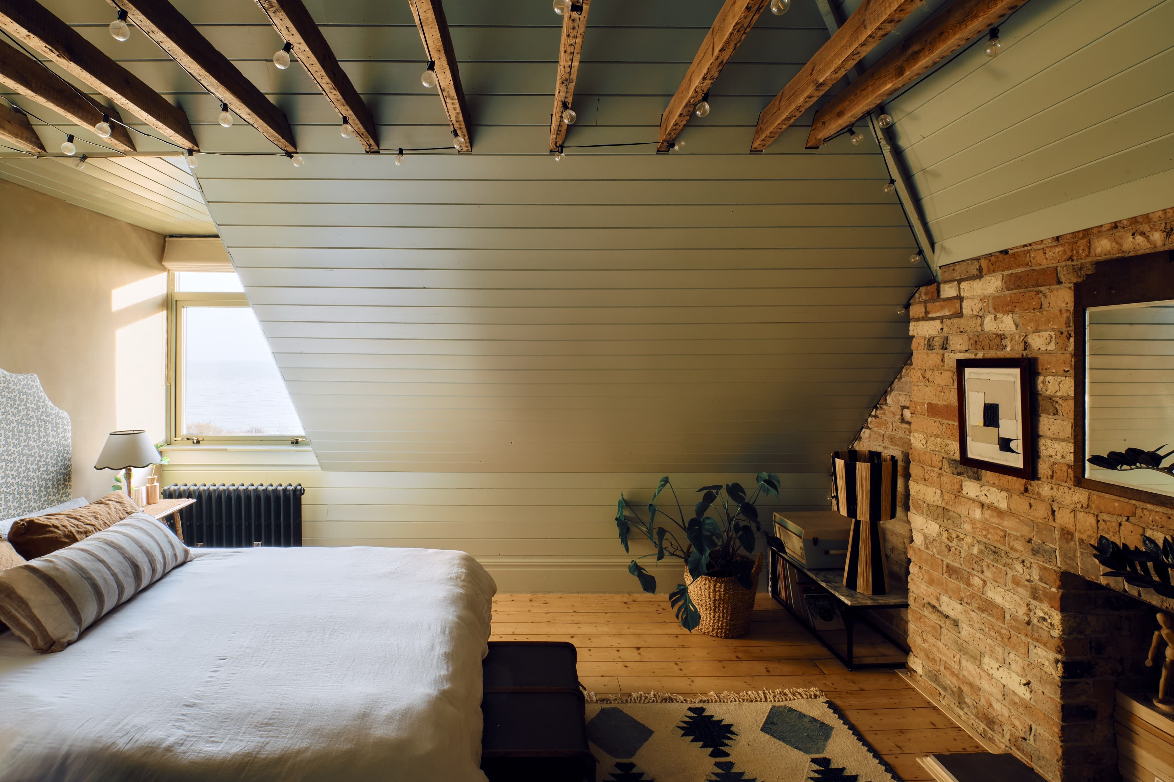 A bedroom under a beamed attic roof